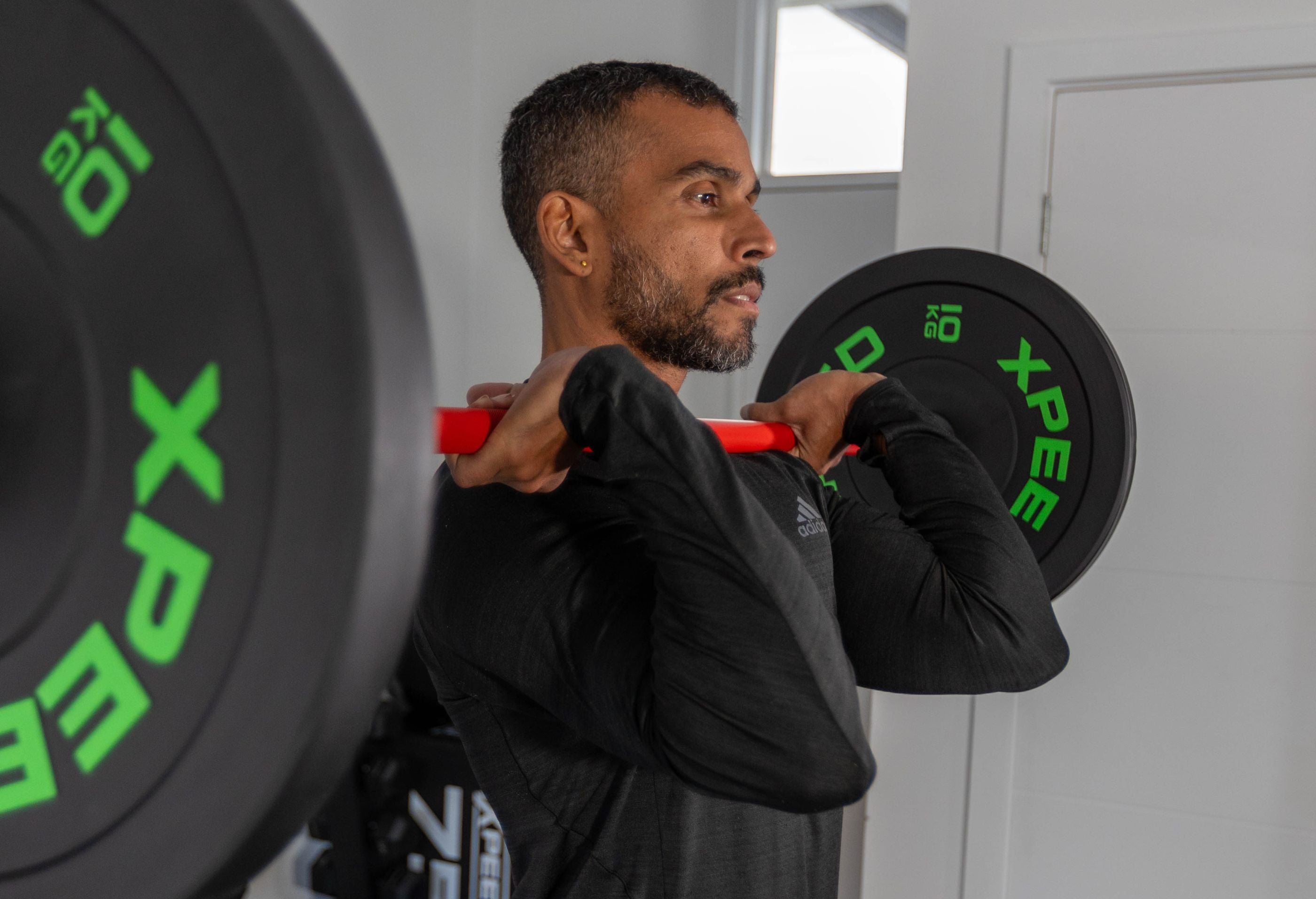 Male training with xpeed barbell and plates