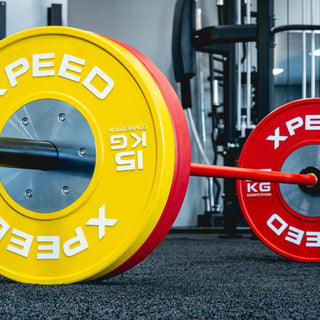 Red Xpeed barbell with bumper plates on it