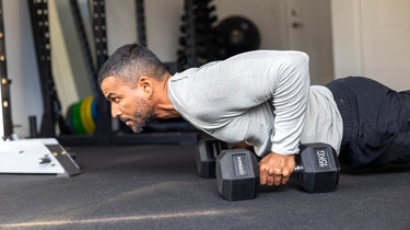 man doing push ups with xpeed rubber hex dumbbells