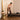 Woman using a Pilates reformer machine in a home setting.