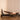 Woman using a Pilates reformer machine in a home setting.