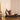 Woman using a Pilates reformer machine in a home setting with a neutral background