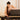 Woman adjusting a Pilates reformer machine in a home setting.