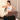 Woman exercising with resistance bands on a Pilates reformer machine.