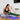 woman stretching with green medium fabric stretch band
