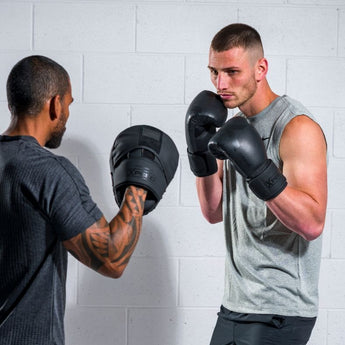 Friends training with professional boxing mitts and professional focus pads